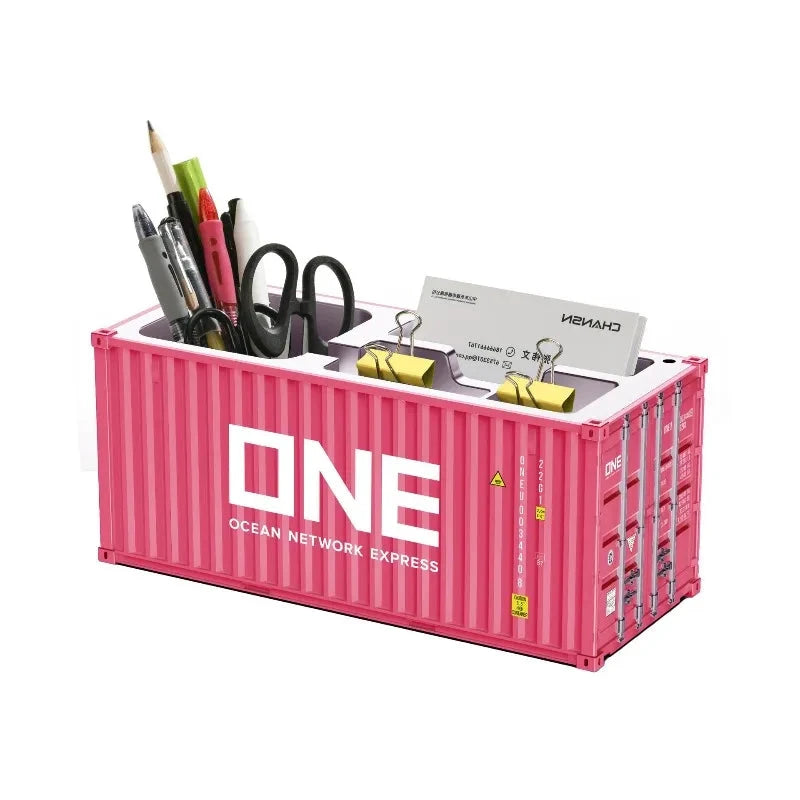 Porte-stylos rose en forme de conteneur maritime; organisateur de bureau ONE avec stylos et ciseaux.