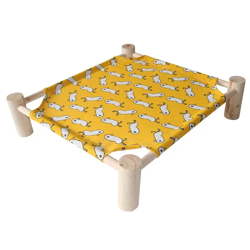 Lit d'extérieur pour chat et petit chien, cadre en bois et toile jaune à motif animaux blancs.
