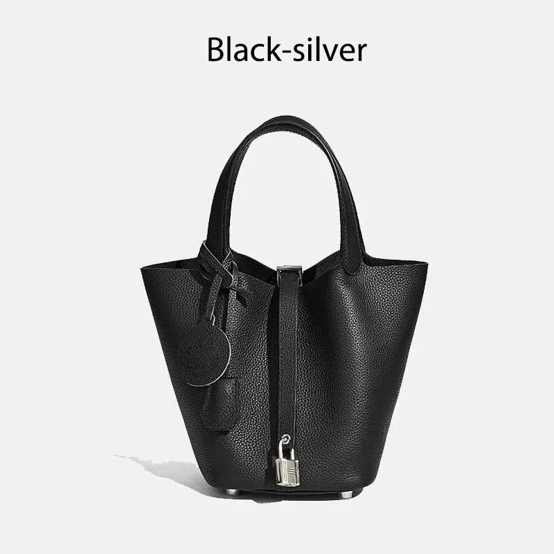 Sac à main seau Mendy en cuir véritable noir, bucket bag avec poignées et cadenas argenté.
