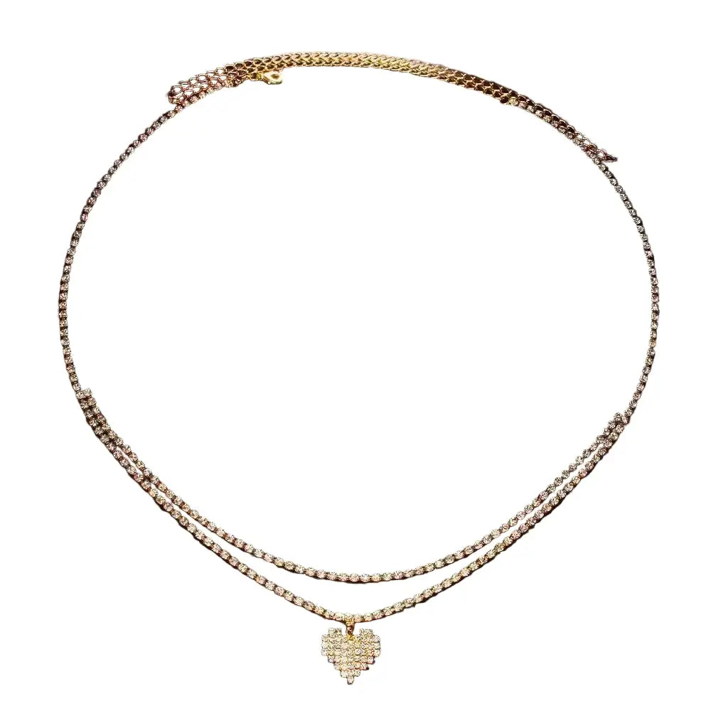 Chaîne de taille double en or, ornée de cristaux goutte d'eau et d’un pendentif cœur pavé de cristaux.