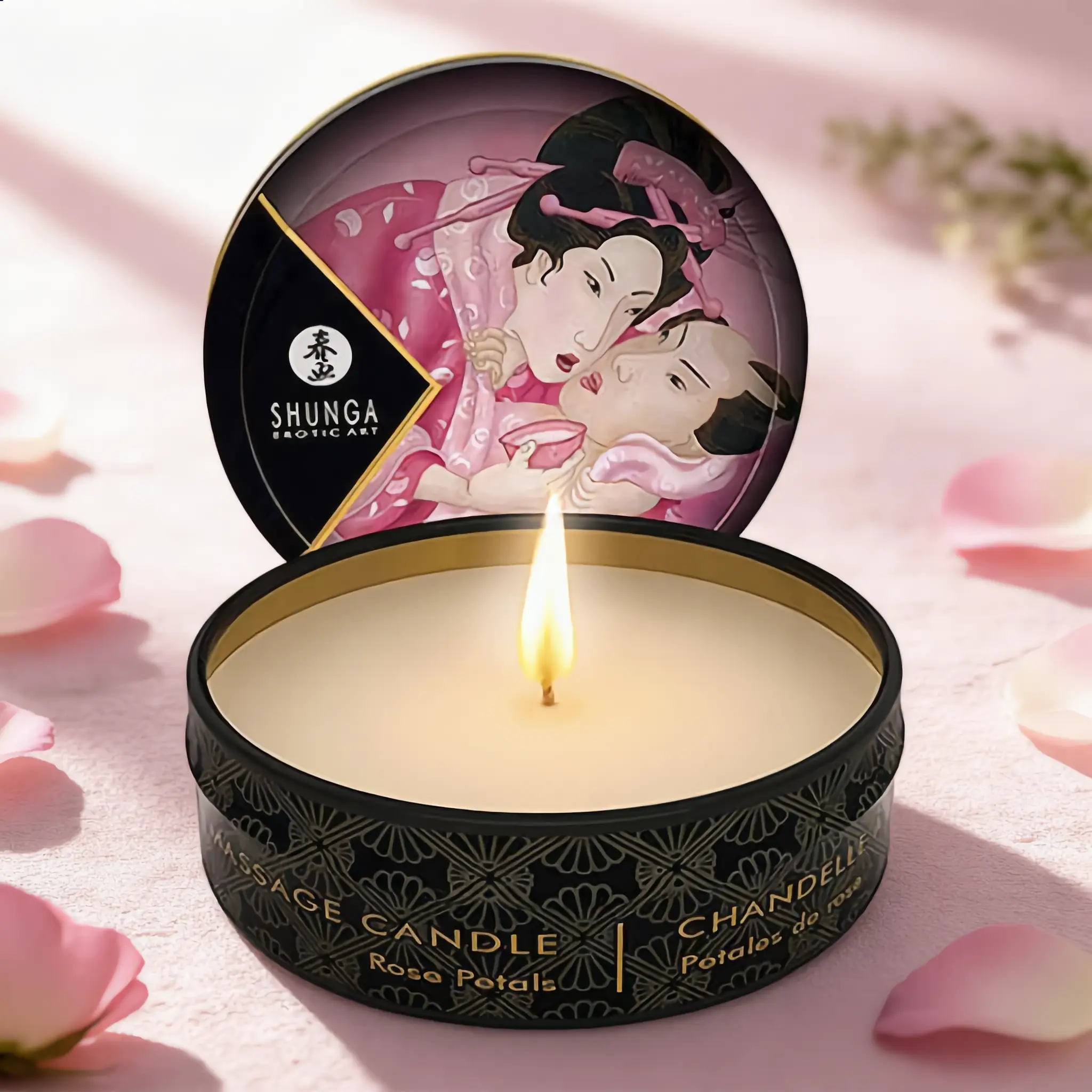Bougie de massage Shunga Roses, 30 ml, boîte ronde noire ornée d’une illustration romantique, flamme allumée