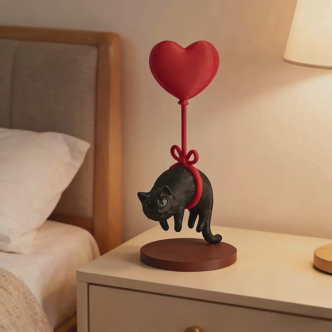 Schwimmende Katzenfigur mit Herzballon